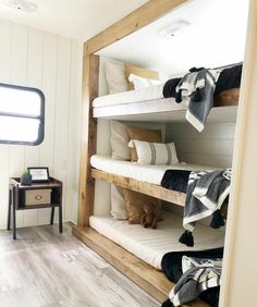 bunk beds are lined up in the corner of a room with white walls and wood flooring