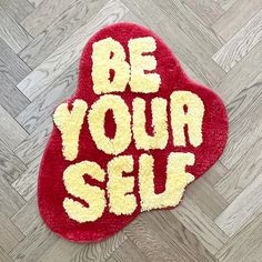 a red and yellow rug with the words be your self written in white on it