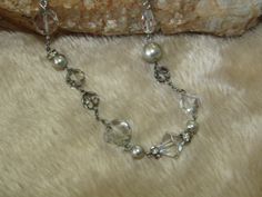 "Vintage Carolee silver tone necklace, adorned with silver faux pearls, clear glass crystals, clear faux crystals, smoky grey faux crystals, and rhinestone rings. Necklace measures 16\" long, with a 2\" extender, which is coppered, as well as the lobster clasp. Tagged with a heart charm signed Carolee. Necklace may need some cleaning." Formal Silver Rhinestone Necklace With Pearls, Formal Silver Rhinestone Pearl Necklace, Silver Pearl Rhinestone Necklace For Formal Occasions, Formal Silver Pearl Rhinestone Necklace, Silver Rhinestone Necklace With Pearl Chain, Elegant Silver Crystal Necklace With Pearl Chain, Silver Crystal Necklace With Pearl Chain, Silver Beaded Crystal Pearl Necklace, Silver Crystal Beaded Pearl Necklace