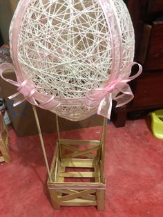 a large balloon sitting on top of a wooden crate next to a box with a bow