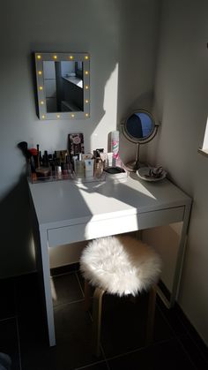 a white desk with a mirror and lights on it