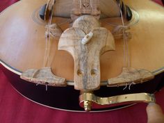 a close up of a wooden guitar with strings attached to the top and bottom of it