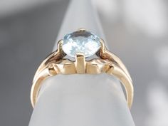 This stunning aquamarine has been set into this Retro era solitaire ring. The cool blue tones contrast beautifully with the warmth of the vintage mounting, while the tapered shoulders draw light into the sparkling gem. This is a lovely piece that is pretty enough to wear alone, yet versatile enough to stack with other rings!Metal: 10K Yellow GoldGem: Aquamarine 1.37 CaratsGem Measurements: 8.5 x 6.9 mm, OvalRing Size: 5.25Marks: "10K" Stamped on the inside band Classic Topaz Ring With Round Cut, Classic Round Cut Topaz Ring, Classic Blue Topaz Solitaire Ring, Classic Topaz Birthstone Ring, Classic Topaz Ring With Center Stone, Classic Blue Topaz Ring With Center Stone, Classic Blue Topaz Ring For Formal Occasions, Classic Formal Blue Topaz Ring, Classic Aquamarine Diamond Ring With Prong Setting