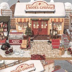 a painting of a store front with snow on the ground and christmas decorations around it