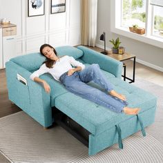 a woman laying on top of a blue couch