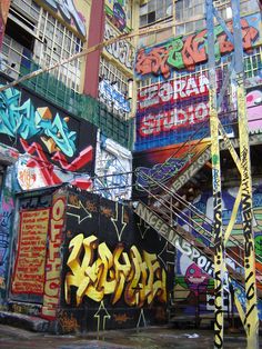 graffiti on the side of a building in an urban area with stairs leading up to it