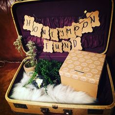 an open suitcase sitting on top of a floor next to a sign that says honeymoon fundd