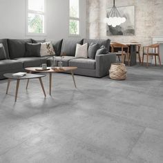 a living room filled with furniture next to a brick wall and floor covered in grey tiles