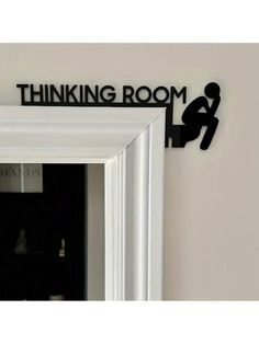 there is a black sign that says thinking room on the side of a wall above a mirror