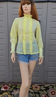 Vintage 70's yellow ruffle shirt .   Metal zipper down the back and semi sheer light weight material.  Has a  few very light  blemishes on the sleeve as pictured.  One button gone on the sleeve cuff.  At the bottom hem line there is a small tear on the back and  couple of grey marks on the front as shown.   Material feels like cotton Measurements are taken with item laying flat so widths across must be doubled  Length = 24   in   sleeves = 24.5  in  Across under arms =  18.5  in width across the Yellow Ruffle Top, Tuxedo Shirt, Tuxedo Shirts, Ruffle Shirt, Sleeve Cuff, Back Shoulder, Top Vintage, Metal Zipper, Ruffle Top