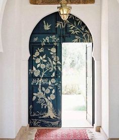 an open door with flowers painted on it and a rug in front of the doorway