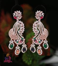 These Rose Gold Polish American Diamond CZ Stone Studded Drop Dangle Earrings are the epitome of luxury and style. Perfect for party wear, these earrings are inspired by Celebrity and Indian Bollywood styles. The Diamond Look CZ Diamond color stones are arranged in a unique peacock design, making these earrings a true work of art from Indian designs. Add a touch of glamour to any outfit with these stunning earrings. Indian Designs, Color Stones, Diamond Jewelry Designs, Peacock Design, Kundan Necklaces, Indian Bollywood, Cz Jewelry, Stone Studs, Drop Dangle Earrings