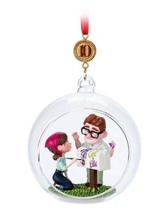 a glass ornament with a boy and girl holding hands in front of each other