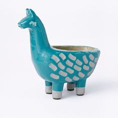 a blue ceramic animal planter sitting on top of a white table