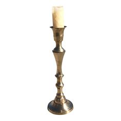 a brass candle holder with a single lit candle in it's center, on a white background