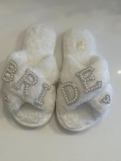 a pair of white slippers with the word dad written on them and sequins