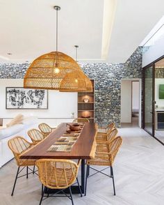 a dining room table and chairs in front of a stone wall