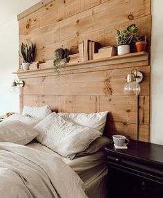 a bed with white linens and wooden headboard