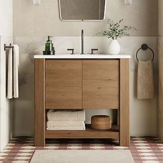 a bathroom with a sink, mirror and towel rack in it's center area