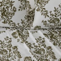 the bedding is made up with white and brown floral designs on it's sheets