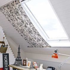 a room with a skylight and various items on the table in front of it