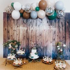 the dessert table is set up with cake and balloons on it for an elegant birthday party