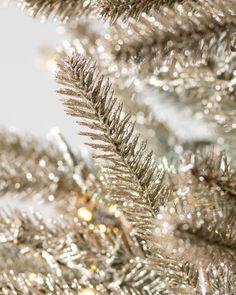 a close up view of the branches of a christmas tree with gold and silver decorations