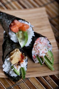 three sushi rolls on a bamboo mat