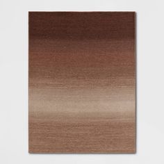 a brown and beige area rug on a white wall