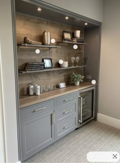 a kitchen with gray cabinets and shelves filled with wine glasses