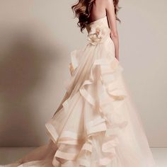 a woman in a wedding dress with flowers on the skirt and headband, posing for a photo