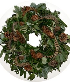 a wreath with pine cones and evergreen leaves