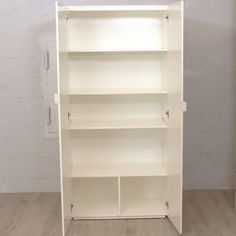 an empty white bookcase on a wooden floor