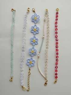 five beaded bracelets are lined up on a table