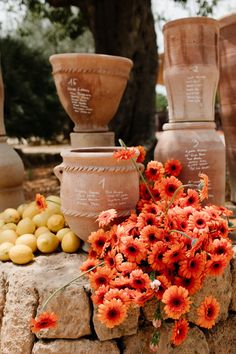 vases and flowers are sitting on a stone wall