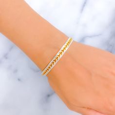 This bangle combines the allure of 22k gold with an opulent design, featuring an elegant interplay of yellow and white gold finishes. It has a light yet substantial feel with a weight of 15.6 grams, signifying high-quality craftsmanship. Tailored with a size of 2.6 and an opening of 2.35 inches, it provides a comfortable and versatile fit for a range of wrist sizes. This piece is crafted for those who appreciate the luxurious charm of gold and seek a sophisticated accessory that melds classic and contemporary styles. Its refined appearance makes it an excellent choice for enhancing any outfit, adding a touch of charm and opulence. PRODUCT DETAILS Gold Purity(karat): 22k Gold Weight(grams): 15.6 Item Finish: Yellow + White Gold Size: 2.6 Bangle Opening: ﻿2.35" Number Of Pieces: 1 Bangle Sty Yellow Gold-plated Bangle Bracelet, Yellow Gold Diamond-cut Bangle Bracelet, Yellow Gold Jubilee Bangle Bracelet, Gold Hand-set Chain Bracelet For Anniversary, Gold Hand-set Diamond Bangle Bracelet, White Gold-plated Bangle Bracelet, Hand Set Gold-plated Diamond Bracelet, Hand Set Gold Plated Diamond Bracelet, Hand Set Yellow Gold-plated Bracelet