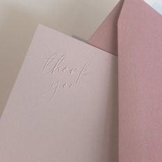 two pink cards with the words thank you written on them, one is folded in half