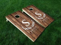 two wooden cornhole game boards with the letter s on them sitting in green grass