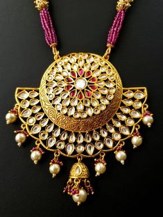 Look beautiful and feel beautiful wearing this gorgeous Indian kundan and pearl pendant necklace in chandbali design. Bright yellow gold colored crescent moon surrounds a stunning pattern of tear drop shaped kundan, which catches the light so nicely! The necklace is outstanding - lush and full multi strand necklace of sparkly faceted red crystals alternating with glowing, delicate tiny pearls. Matching jhumka earrings with pearls and red crystal accents, and clear and red stones. Effect is stunn Kundan Pendant Necklace With Meenakari, Chandbali Bridal Necklace For Celebrations, Festive Kundan Pendant Necklace With Cutdana, Kundan Pearl Pendant Necklace For Festivals, Kundan Temple Jewelry Necklace With Pearl Pendant, Festive Kundan Pendant Necklace For Diwali, Chandbali Kundan Temple Necklace For Navratri, Diwali Temple Jewelry Kundan Necklace With Pearl Pendant, Diwali Festive Kundan Pendant Necklace