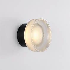 a light that is on the side of a wall with a black and white base