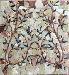 a decorative glass tile with leaves and flowers on it's side, in the shape of a tree