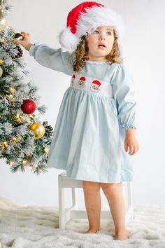 PRE-ORDER - SHIPPING IN NOVEMBER. ESTIMATE DELIVERY DATE  PLEASE READ: If you are ordering in stock items along with PRE-ORDER items, they will ship on the PRE-ORDER listing date. If you need the in stock item earlier, please place a separate order.    Comfortable light blue smocked corduroy dress with embroidered Santas, perfect for all this holiday season has to offer! Clothing Care Instructions: Machine wash gentle. Do not bleach. Tumble dry delicate at low heat. Iron at medium. If the item that you are ordering has red or another bright color in it next to a white or other light color fabric please use a Shout color catcher for the first few washes to avoid bleeding.  Follow us on Instagram @thelillieandlilahshop for shop discounts and updates! Cute Long Sleeve Smocked Dress With Smocked Cuffs, Cotton Long Sleeve Dress With Smocked Back, Long Sleeve Cotton Smocked Dress With Smocked Cuffs, Long Sleeve Cotton Dress With Smocked Bodice, Corduroy Dress Outfit, Kids Christmas Outfits, Winter Dress Outfits, Corduroy Dress, Smocked Dress