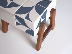 a blue and white bench with wooden legs