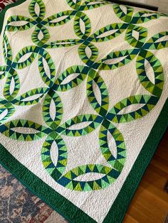 a green and white quilt on top of a bed