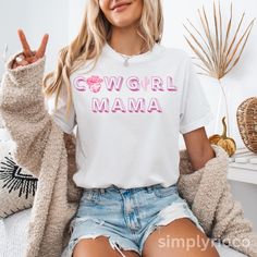 This cowgirl mama t-shirt exudes a laid-back, Western vibe perfect for moms who love the ranch life. It's a stylish and comfortable addition to any mom's wardrobe, ideal for casual outings and family gatherings. This tee is relevant for Mother's Day, birthdays, and everyday wear Product features - Made with 100% Airlume combed and ring-spun cotton for lightweight and breathable comfort - Retail fit for versatile styling in casual and semi-formal settings - Bella+Canvas manufacturing in the US an Relaxed Fit Letter Print T-shirt For Rodeo, Western Mama Shirts, Black Western Style T-shirt For Rodeo, Trendy Relaxed Fit Rodeo T-shirt, Relaxed Fit Cotton T-shirt For Rodeo, Cowgirl Life, Mom Wardrobe, Mama T Shirt, Ranch Life