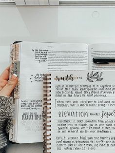 a person holding an open book with writing on it