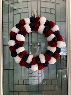 a red, white and blue wreath hanging on the front door