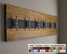 a wall mounted coat rack with six hooks and four coats hanging on it's sides