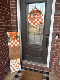 a front door decorated with an orange and white checkered welcome sign