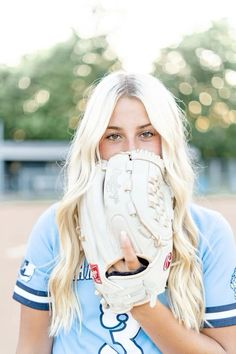 a woman with blonde hair wearing a catchers mitt